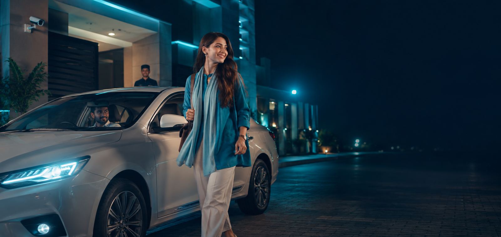 Rider walking toward a car at night